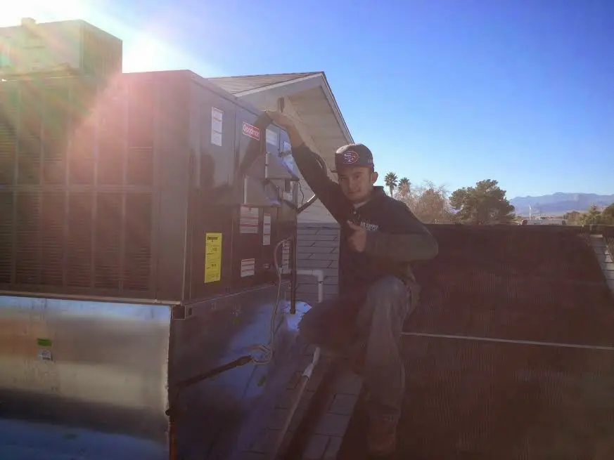 HVAC technician performing Boiler Repair on a rooftop unit in North Branch